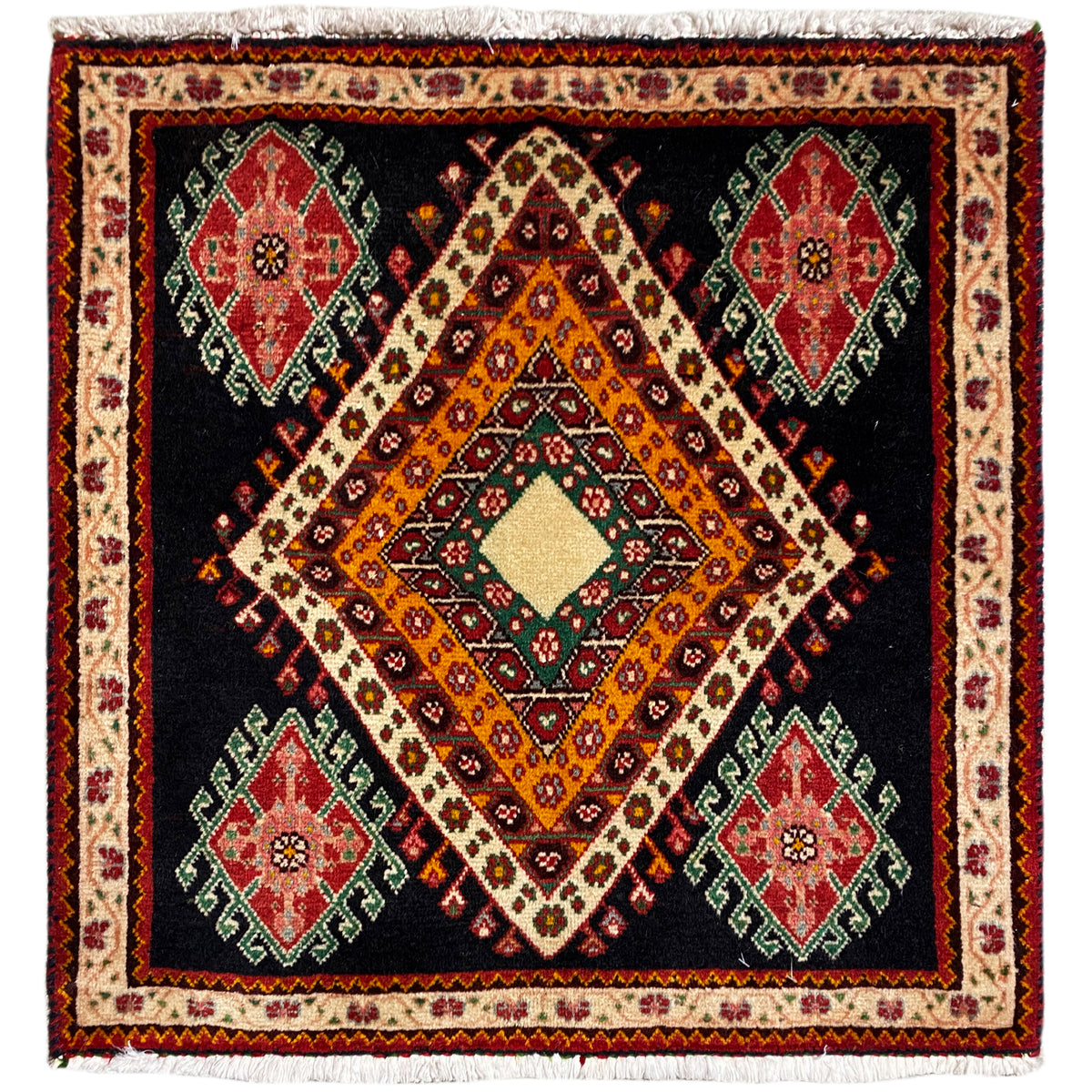 Alfombra Poshti de formato cuadrado con fondo negro, diseño central de rombos y medallones de colores