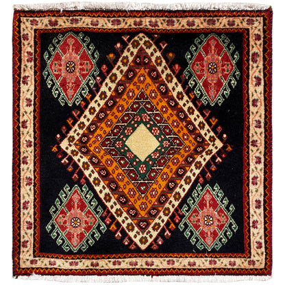 Alfombra Poshti de formato cuadrado con fondo negro, diseño central de rombos y medallones de colores