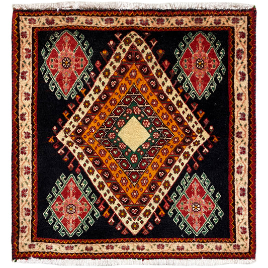 Alfombra Poshti de formato cuadrado con fondo negro, diseño central de rombos y medallones de colores