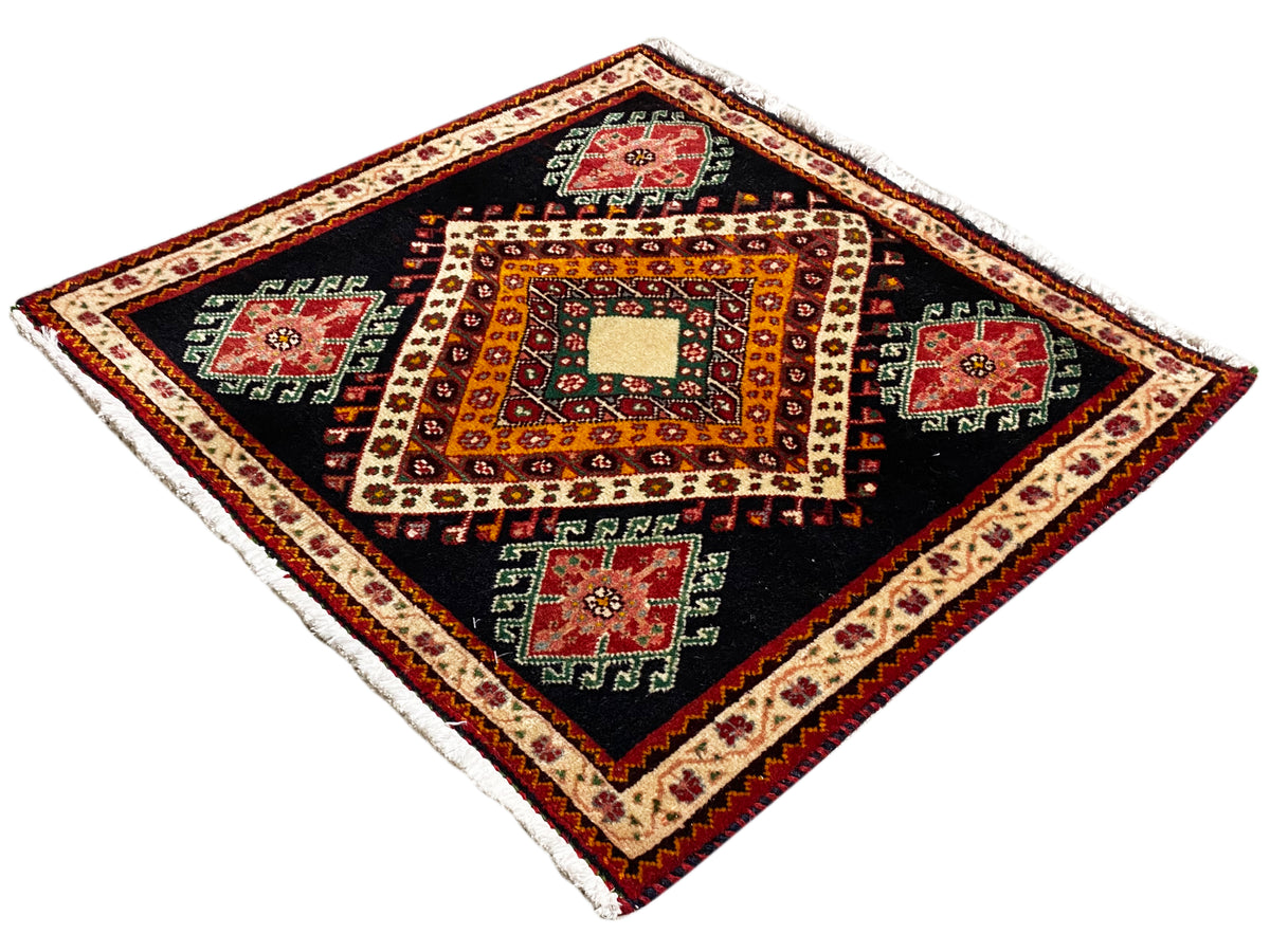 Alfombra Poshti en ángulo de diamante con fondo negro, rombo blanco central y borde multicolor