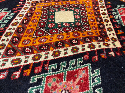 Vista detallada de una alfombra Poshti con rombo principal de color naranja amarillento, pequeños elementos ornamentales y centro blanco