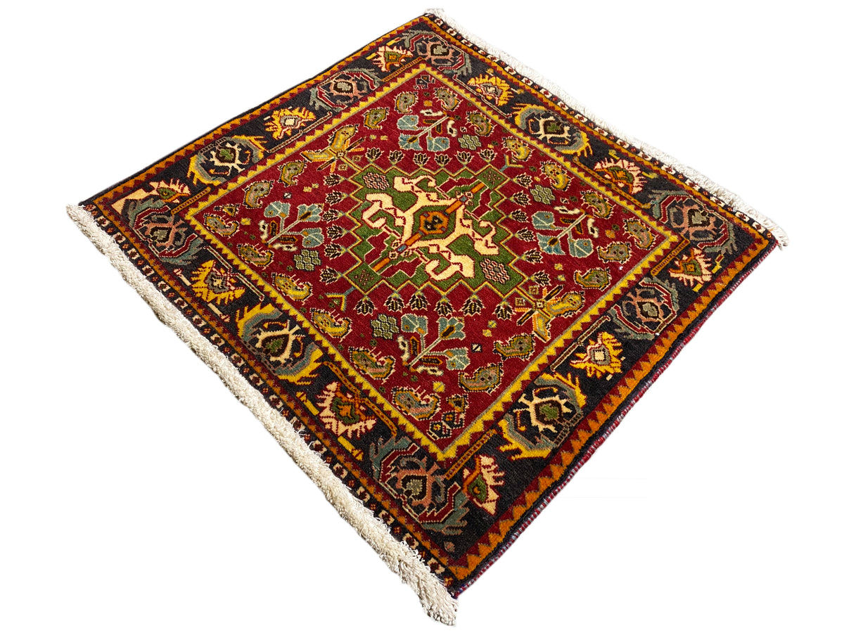 Alfombra Poshti de 61x61 cm, vista de esquina, roja con inserción ornamental de colores