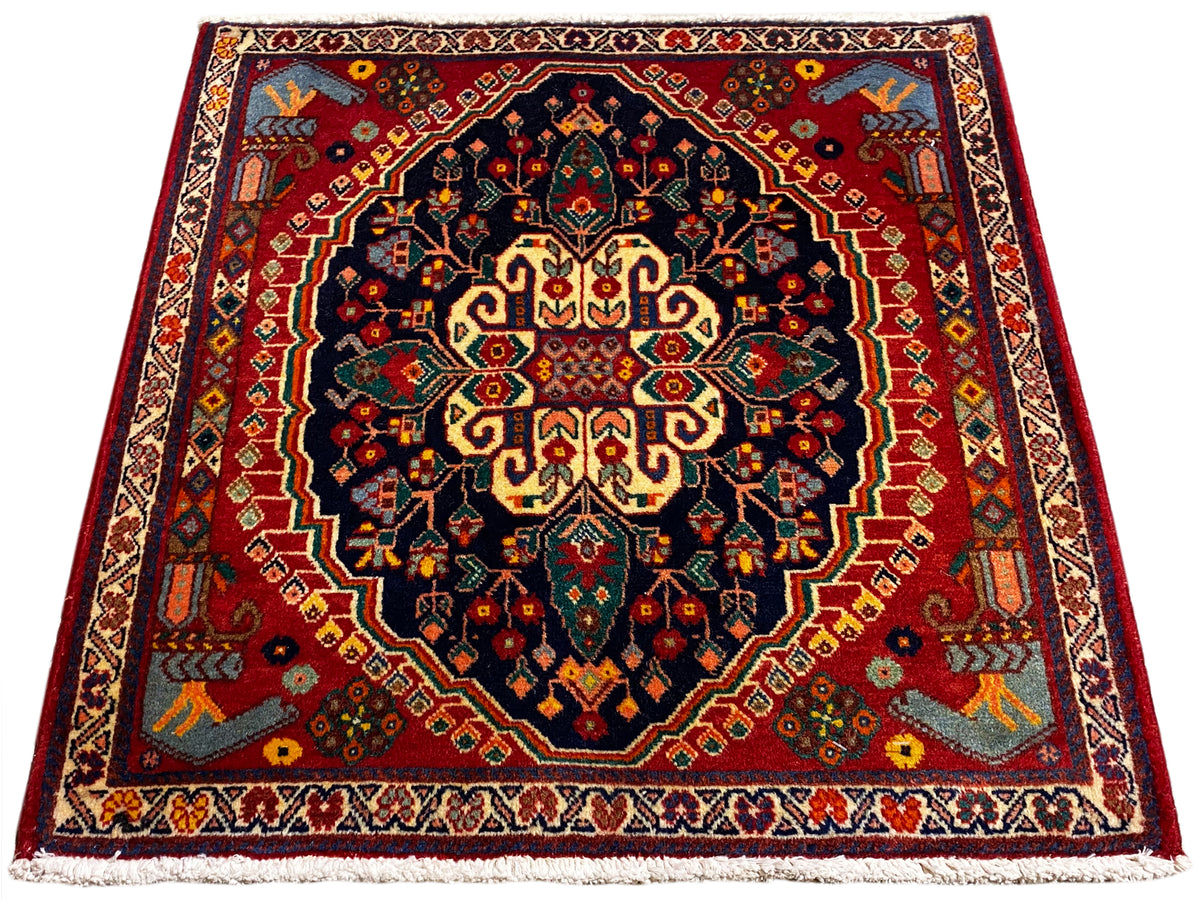Alfombra cuadrada de 67x60 cm con diseño centrado en azul oscuro, rojo y amarillo