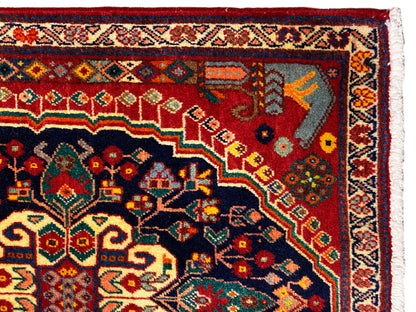 Detalle de la alfombra: ornamento colorido en la zona azul oscuro con fondo rojo