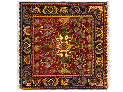 Alfombra con campo interior rojo, ornamentos verde-amarillos y un diseño de cenefa oscura