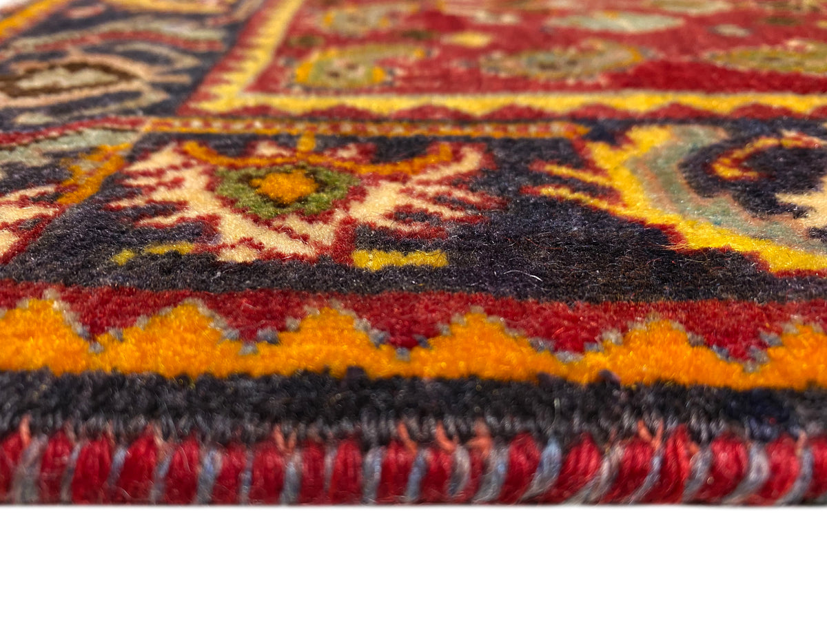 Remate de alfombra con flecos y borde estampado en rojo, naranja, azul y negro