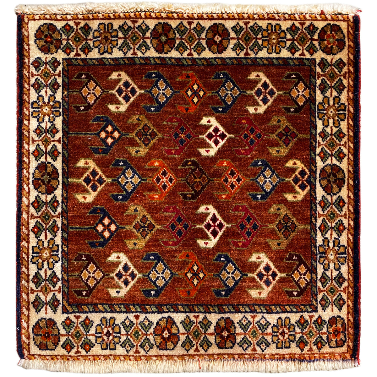 Alfombra Poshti de 60x55 cm con diseño geométrico en rojo, marrón, azul y crema