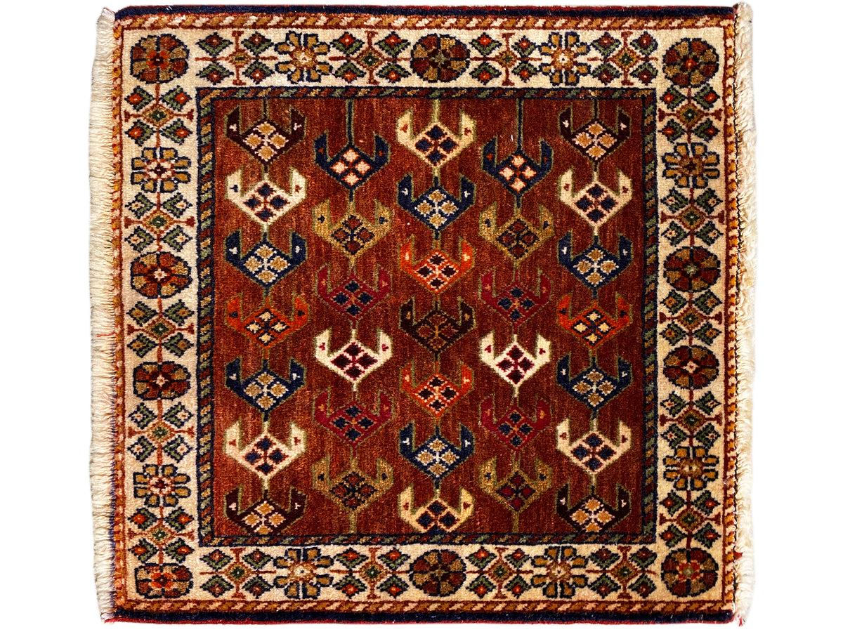 Alfombra Poshti cuadrada de 60x55 cm, ornamentos geométricos en marrón rojizo, azul y crema