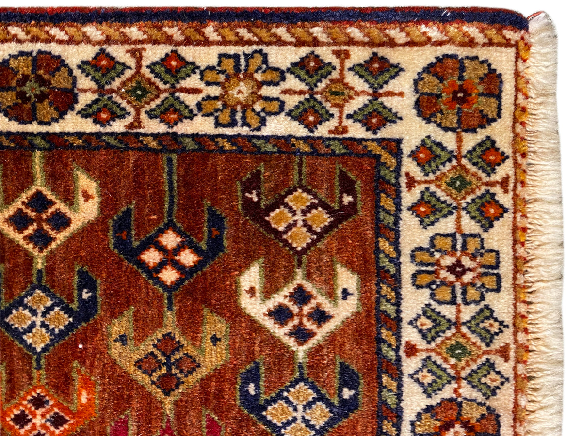 Alfombra Poshti 60x55 cm Detalle: banda ornamental y rombos centrales en marrón rojizo