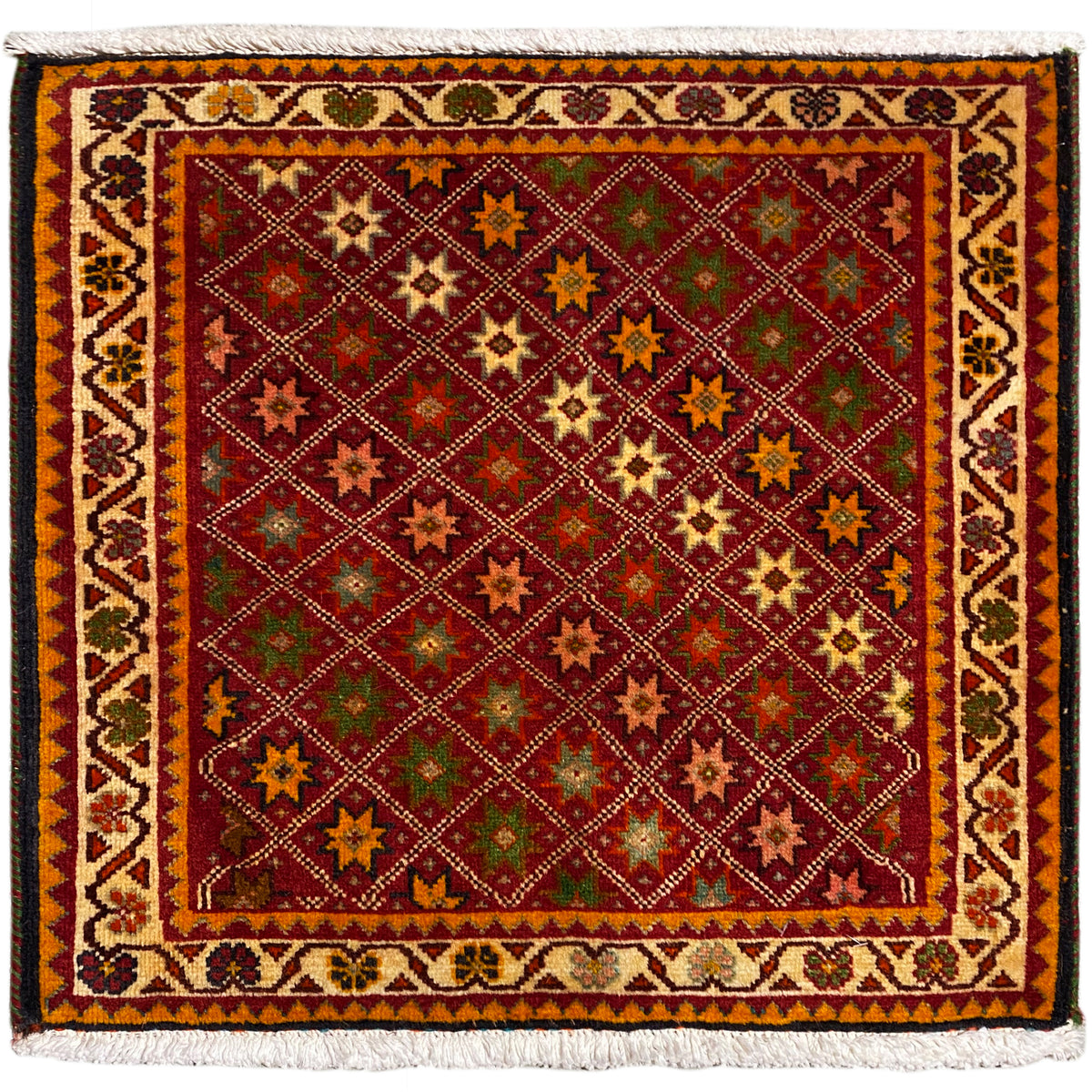 Alfombra poshti, rectangular, multicolor, con motivos ornamentales de estrellas y borde con flecos.