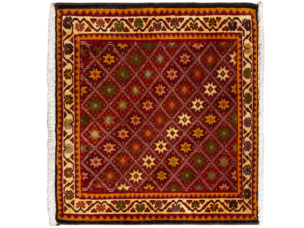 Alfombra Poshti rectangular, con decoración multicolor de motivos de estrellas y rombos en el campo interior.