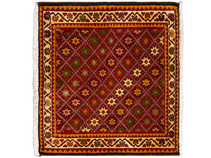Alfombra Poshti rectangular, con decoración multicolor de motivos de estrellas y rombos en el campo interior.
