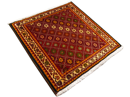 Alfombra Poshti, rectangular, vista diagonal: campo interior rojo con motivos de estrellas y cenefa.