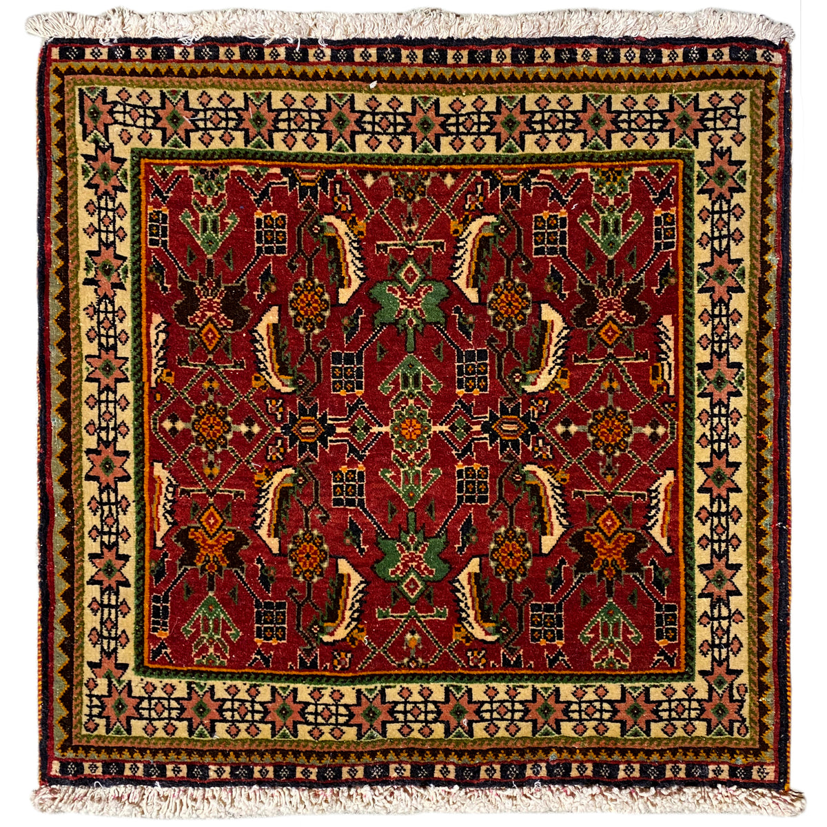 Alfombra Poshti de 63x61 cm con estampado rojo y verde y flecos en el borde.