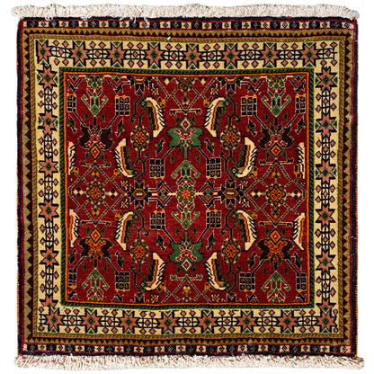 Alfombra Poshti de 63x61 cm con estampado rojo y verde y flecos en el borde.