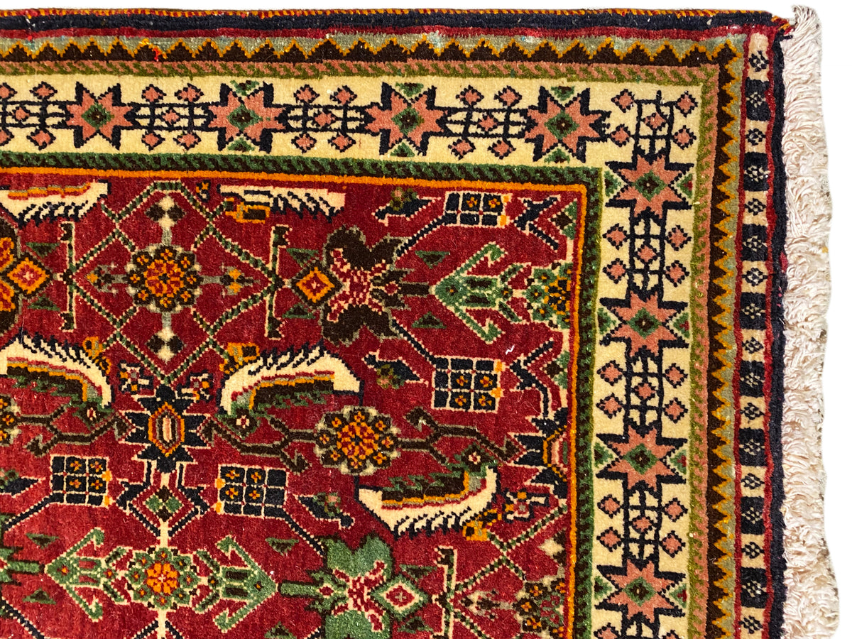 Alfombra Poshti de 63x61 cm, vista detallada: campo ornamental rojo con motivos verdes y amarillos.