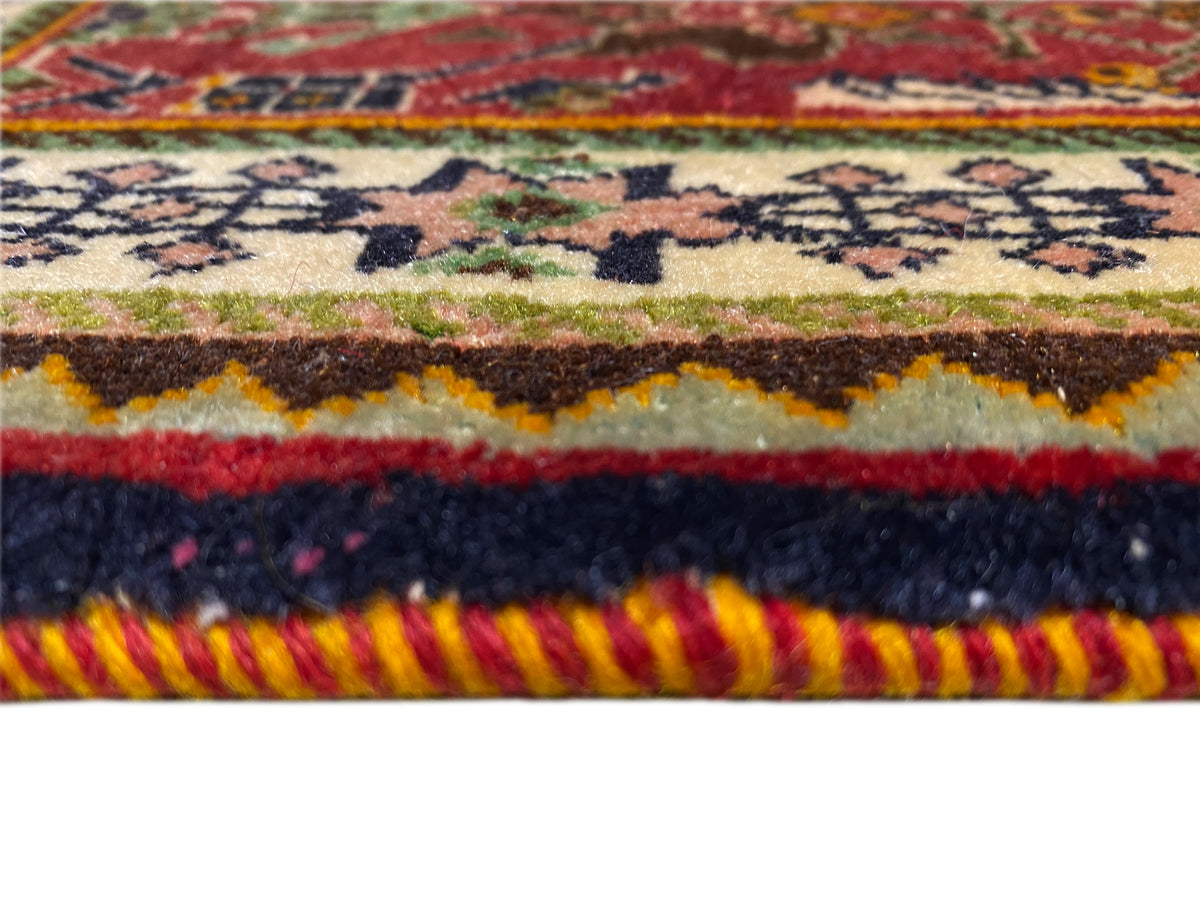 Alfombra Poshti de 63x61 cm en primer plano: borde tejido multicolor con flecos y textura pronunciada.