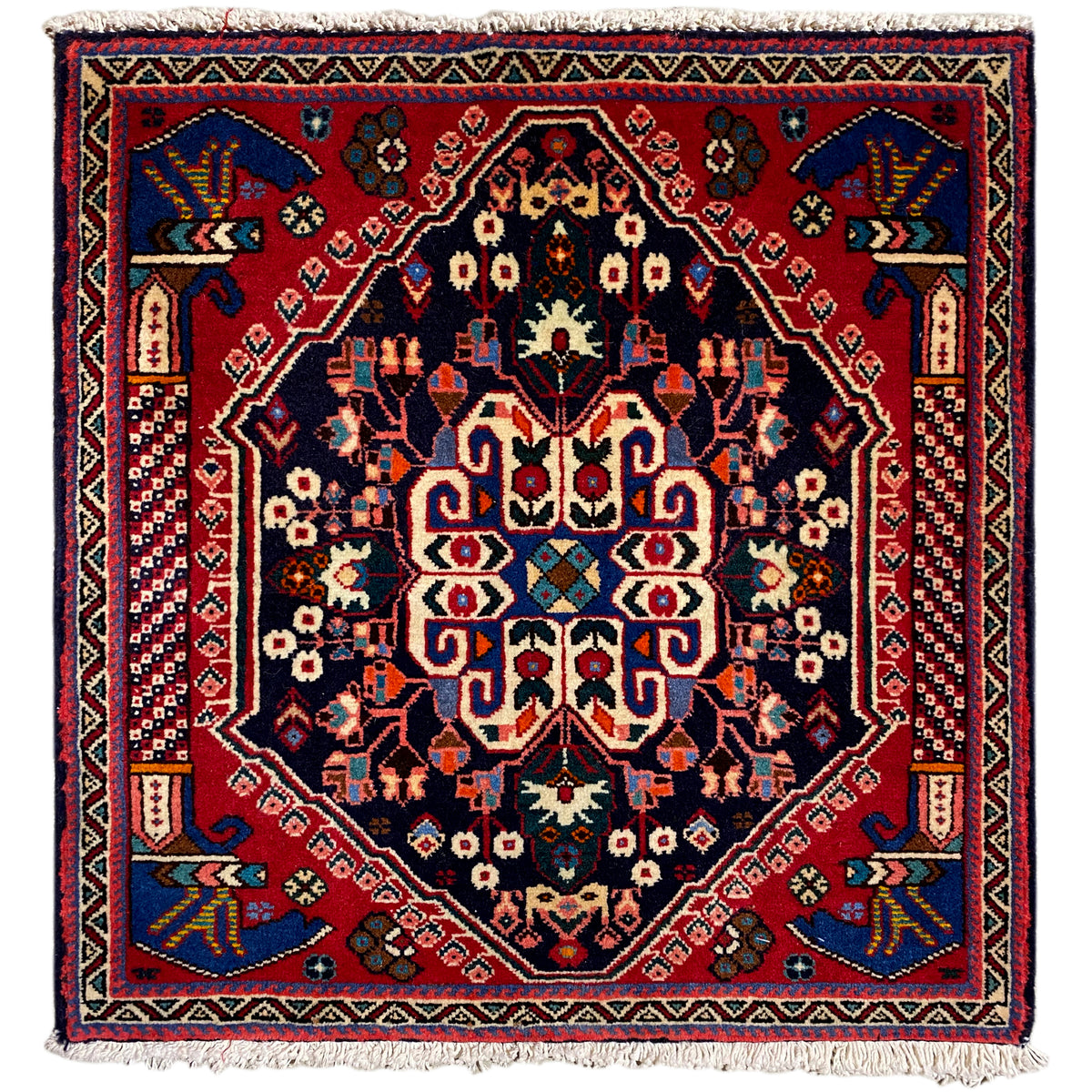 Alfombra Poshti de 66x63 cm con azul oscuro, rojo y un detallado diseño ornamental