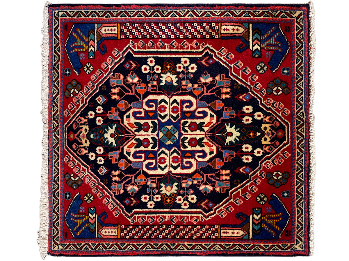 Alfombra Poshti de 66x63 cm con borde rojo, azul oscuro y patrón geométrico