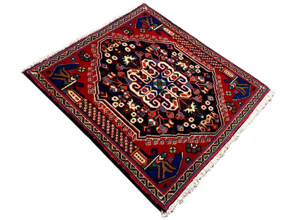 Alfombra Poshti de 66x63 cm, campo azul oscuro, marco rojo y motivos florales