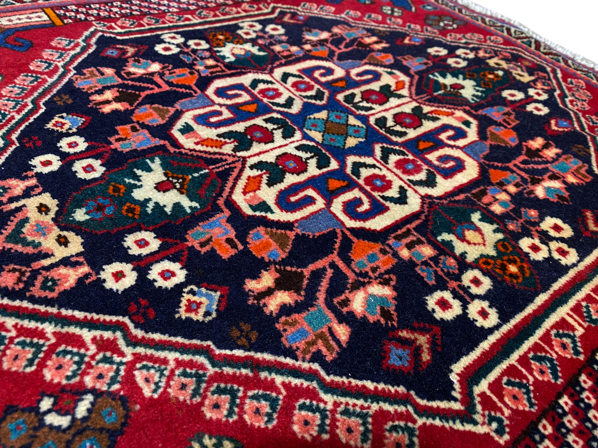 Alfombra Poshti de 66x63 cm en primer plano: ornamento central, estrellas y rombos de colores