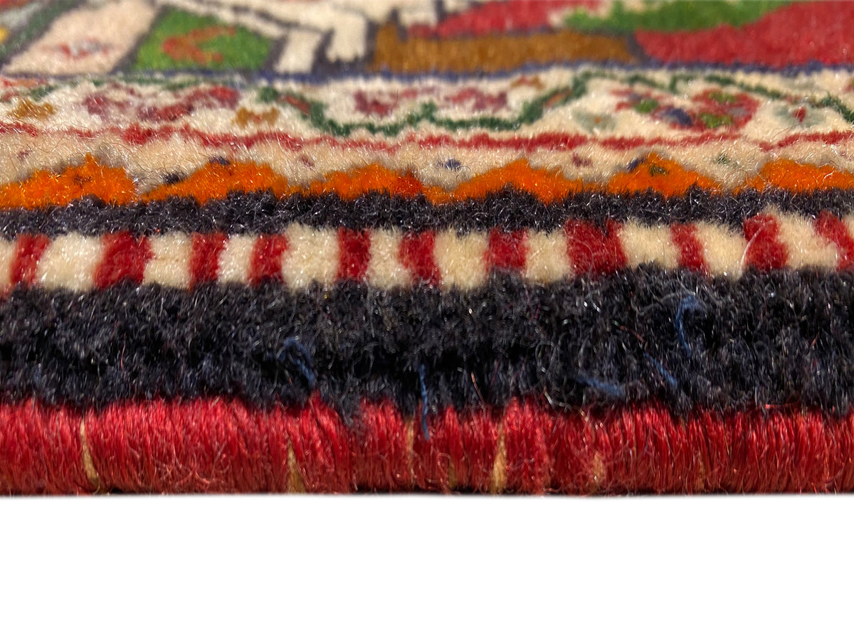 Detalle de la alfombra Poshti: pelo multicolor con borde de flecos negros y rojos
