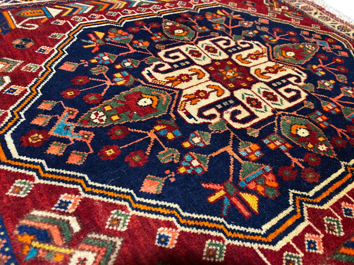 Alfombra de 63x60 cm en primer plano: patrón floral colorido sobre fondo azul oscuro