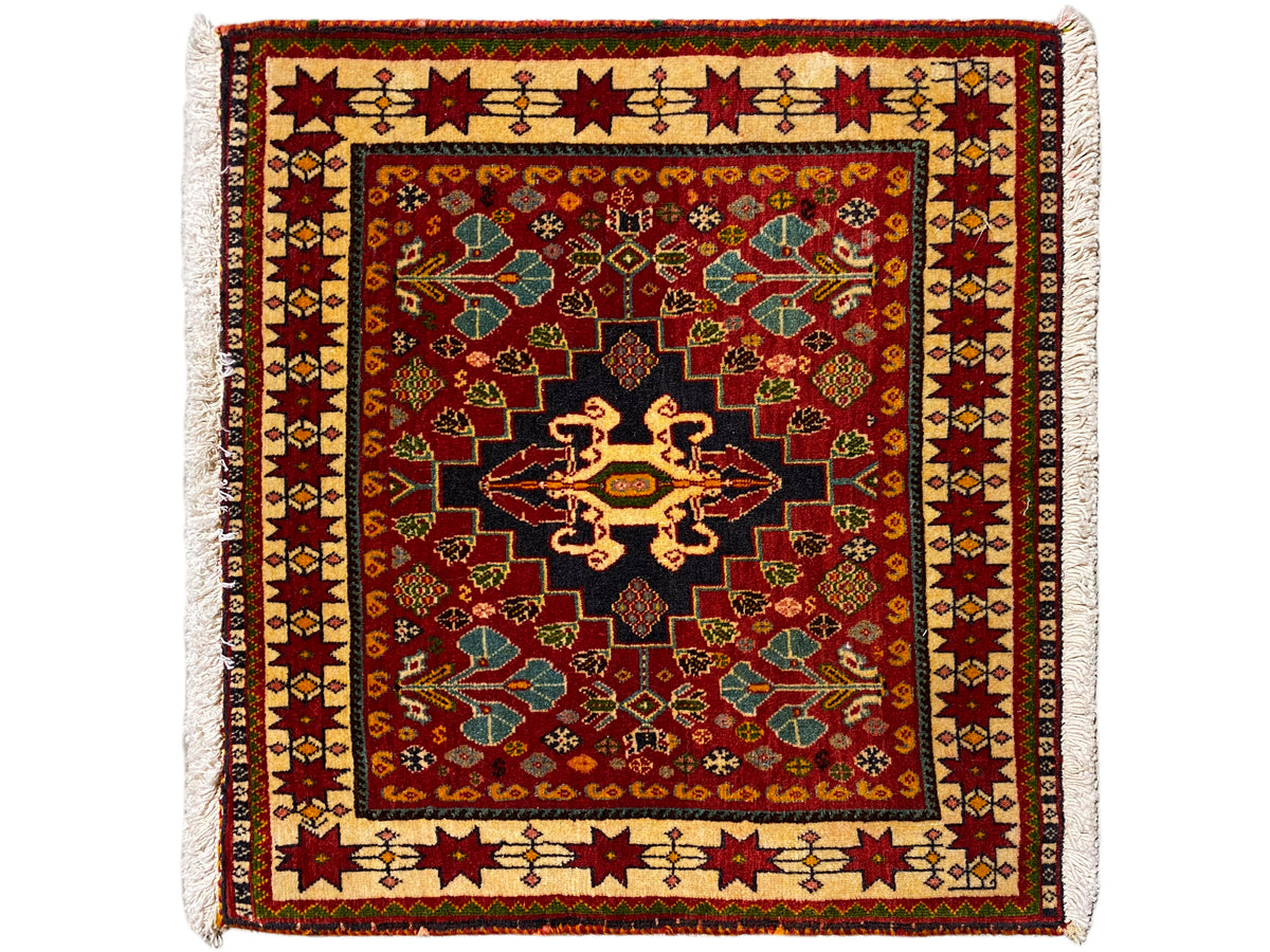 Alfombra de 60x58 cm: ornamento rojo, centro negro, borde de colores, flecos