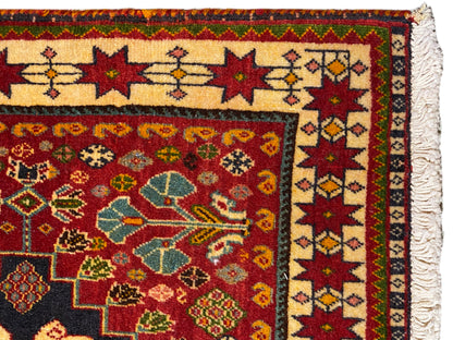 Alfombra en detalle: cenefa multicolor y motivos ornamentales, borde lateral con flecos