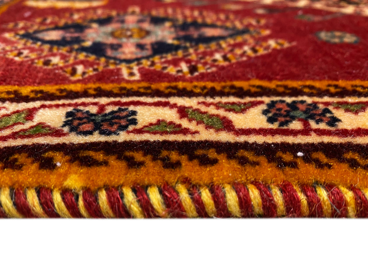Detalle del borde de la alfombra Poshti: flecos y cenefas multicolores