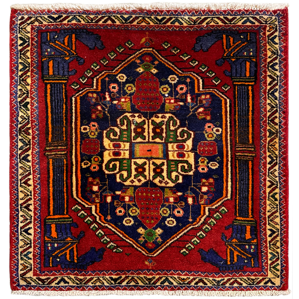 Alfombra Poshti, cuadrada, 66x62 cm, con diseño rojo y remates decorativos azules y amarillos.