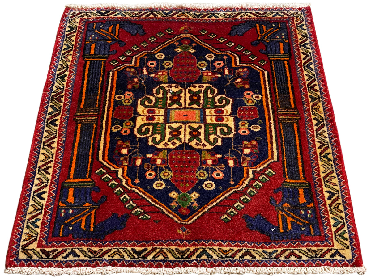 Alfombra Poshti de 66x62 cm extendida en plano: medallón central rojo con ornamentos geométricos.