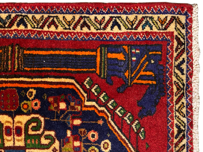 Alfombra Poshti de 66x62 cm, vista de cerca: franja de cenefa y campo ornamental azul oscuro.