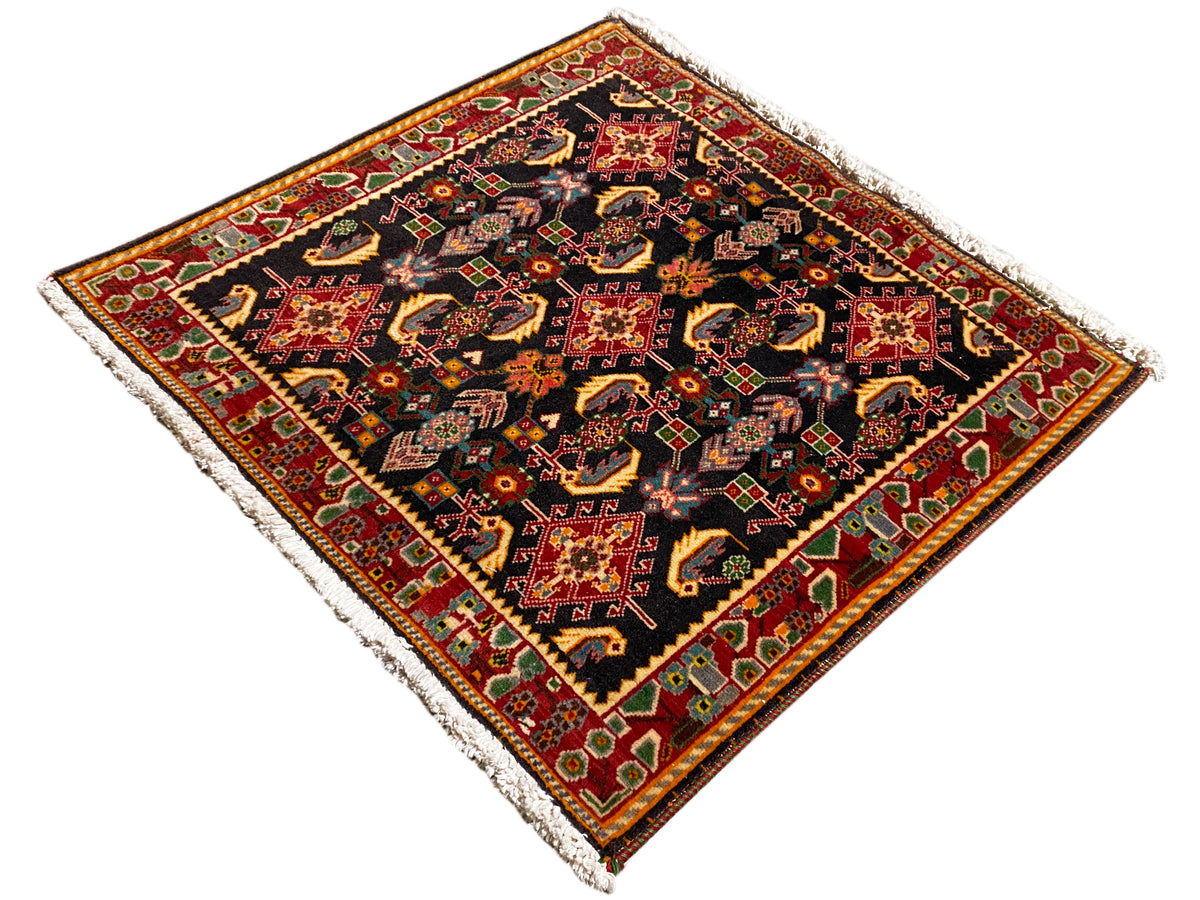 Alfombra con ornamento central decorativo, negro, tonos rojos y amarillos, acentos verdes