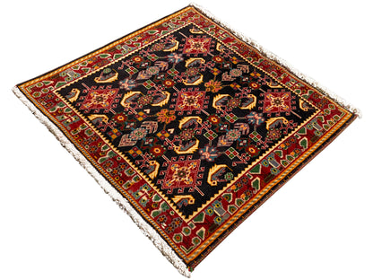 Alfombra con ornamento central decorativo, negro, tonos rojos y amarillos, acentos verdes