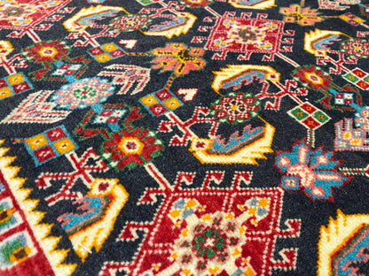 Superficie de alfombra con un colorido patrón geométrico en negro, rojo, verde y amarillo