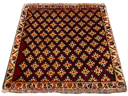 Alfombra Poshti de 61x59 cm: alfombra de color rojo oscuro con diseño de rombos y borde de flecos alrededor
