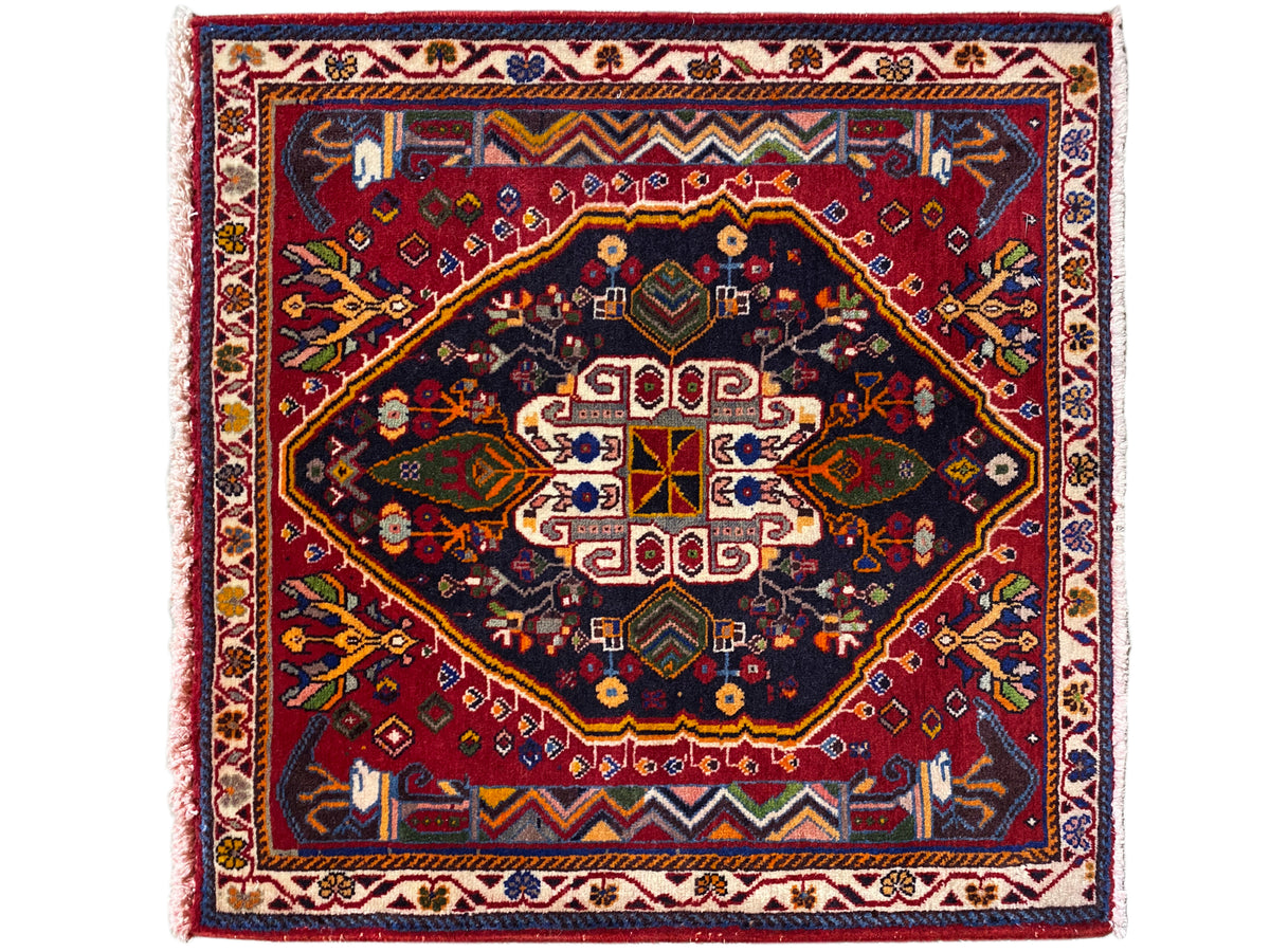 Alfombra Poshti (67×67 cm) con composición de medallones de varias partes, en azul oscuro y rojo