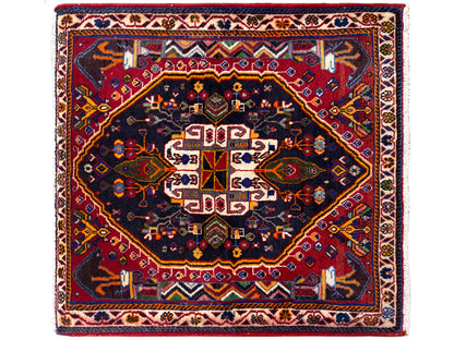 Alfombra cuadrada con fondo azul oscuro, marco rojo y ornamento centrado, 70x67 cm