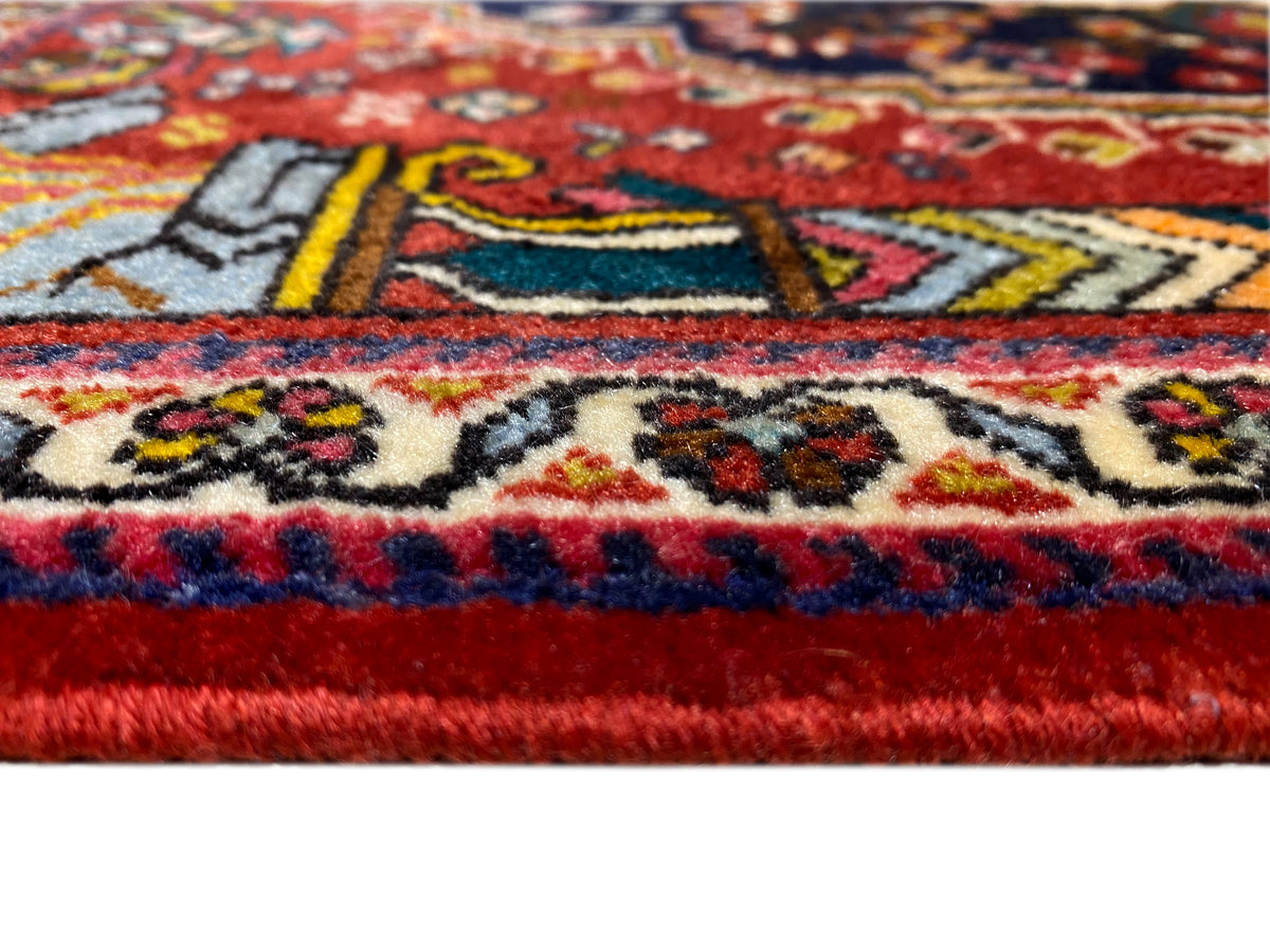 Alfombra Poshti de 65x61 cm, primer plano de la cenefa: ornamentos rojos, azules y multicolores