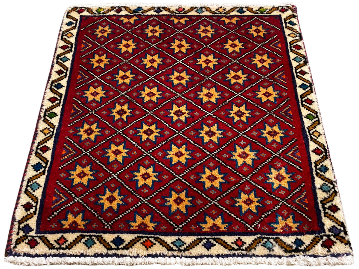 Alfombra cuadrada con fondo rojo y estrellas doradas, azules y negras